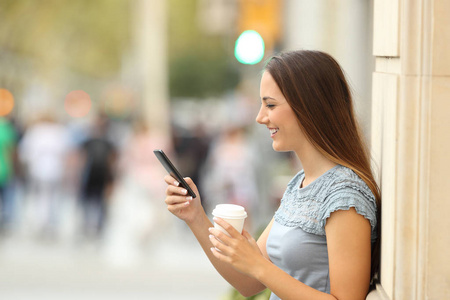 在街道上使用智能手机的女孩的侧面视图照片