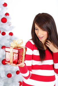 礼品盒白色圣诞节树旁边的漂亮女孩