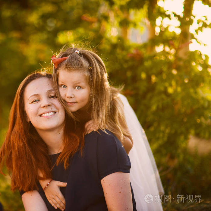 年轻漂亮的 redhaired 妈妈和妹妹带着一个可爱的女儿微笑着拥抱在