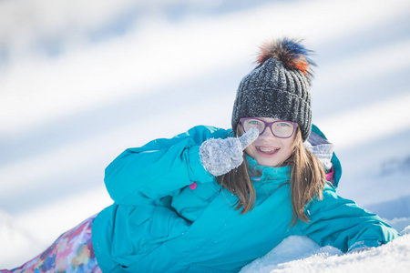 愉快的年轻女孩在温暖的衣物玩雪的前少女