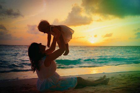 母亲和小女儿玩在日落时分