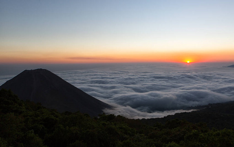 日落时, 火山 Izalco 升起在云层之上