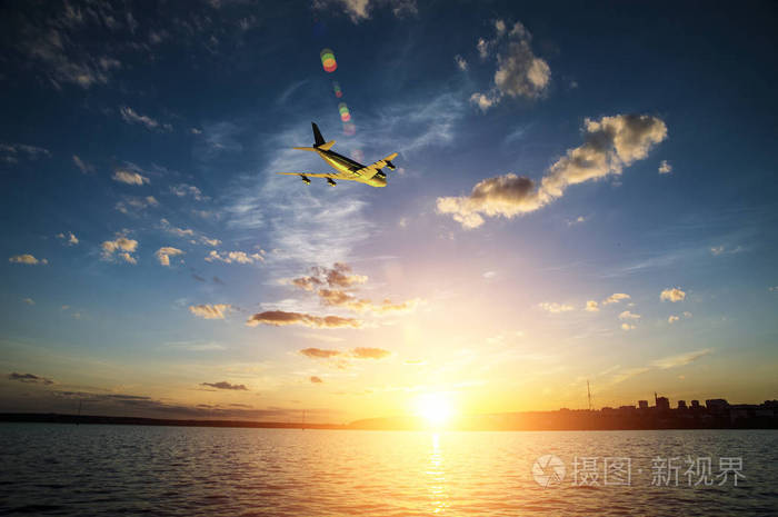 飞机爬升,在日落时分飞越大海向太阳