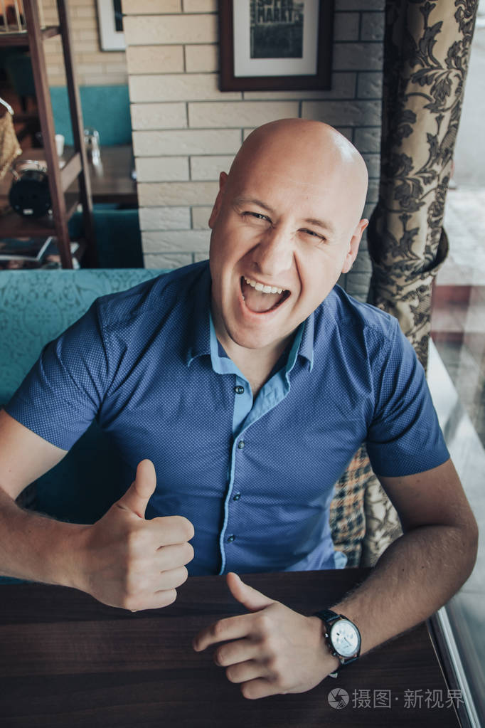 滑稽的生意人坐在桌附近