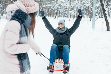 小情侣雪橇在公园冬日的部分看法