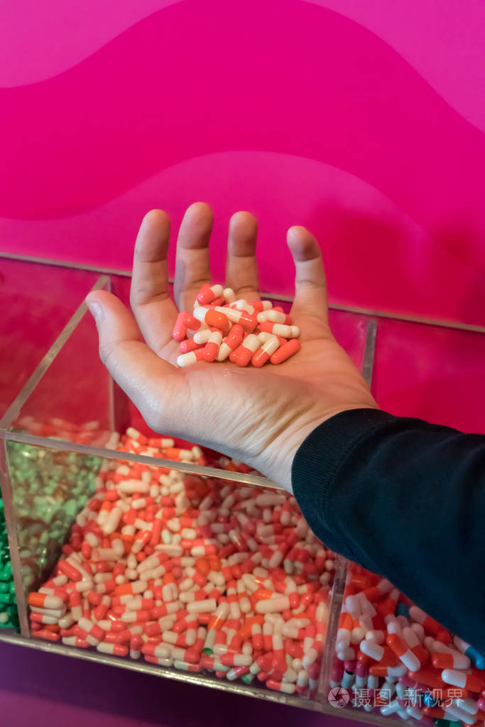 妇女手捧粉红色和白色胶囊药物组