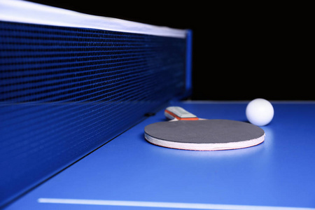 乒乓球拍和球近网桌图片