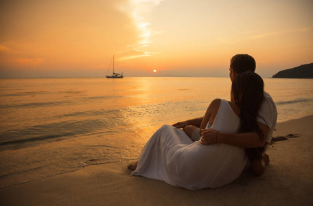 浪漫迷人情侣肖像在热带岛屿日落时, 拥抱在沙滩上.