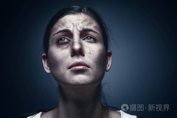关闭了与感到受伤的皮肤和黑色的眼睛哭的女人的肖像