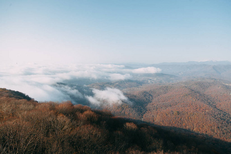 在索契的山地物种在一个红色的空地, 积雪覆盖的山峰, 在云层之上的看法