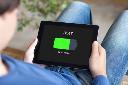 男子手持平板电池在屏幕上充电照片