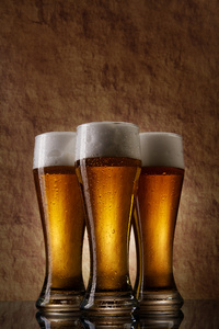 三个啤酒成旧的石头上玻璃