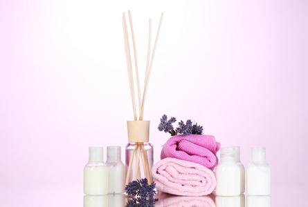 瓶空气清新剂 薰衣草和毛巾上的粉红色背景