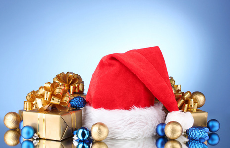 美丽的圣诞帽子 礼品及圣诞球在蓝色背景