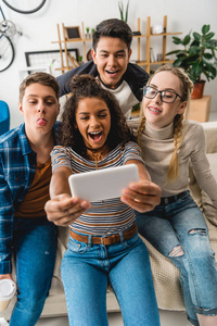 快乐的多民族青少年利用智能手机自拍
