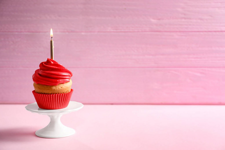 美味的生日蛋糕与燃烧蜡烛在桌子上对颜色背景