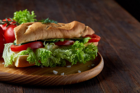 新鲜的三明治与生菜, 西红柿和奶酪服务于木质板材的木质背景, 选择性聚焦