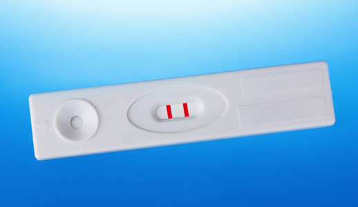 蓝色背景上的正面妊娠试验。