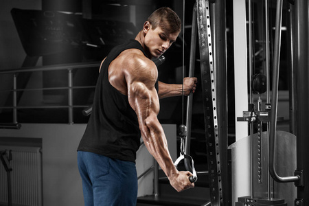 肌肉男在健身房锻炼肱三头肌，强烈的男性在工作