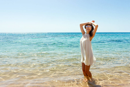 在沙滩上享受夏日自由的女人。海滩上的开心女孩