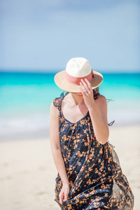 在热带海滨享受乐趣的年轻美丽的妇女。快乐的女孩漫步在白沙热带海滩