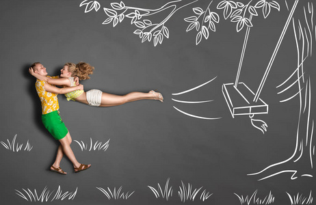 快乐情人节爱浪漫的情侣粉笔图纸背景故事概念。抓住他的女朋友从树上跳下来的男性波动