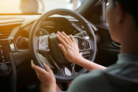 按驱动器妇女按喇叭, 而驾驶汽车通过道路照片