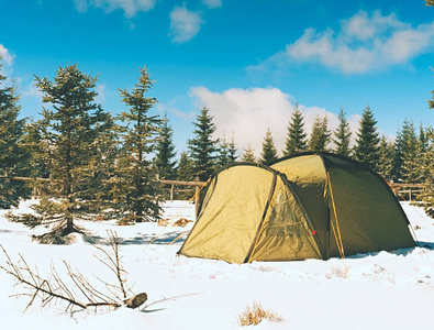 帐篷在冬天风景。徒步帐篷, 杆子, 红色穿雪鞋在树之间的雪