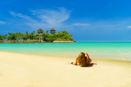 海边日光浴美丽的女人在海边晒日光浴比基尼照片