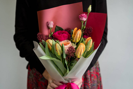 女人捧着时髦的红花花束