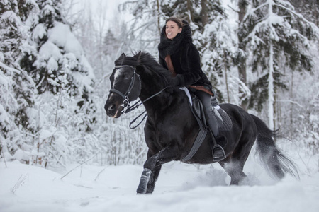 冬天森林里骑着黑马穿过雪地的女孩背景