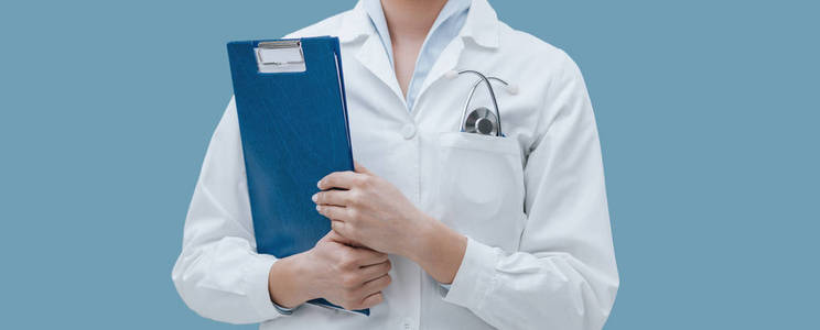 专业女医生持有剪贴板和摆姿势, 医疗专业人员的概念