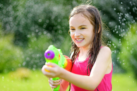 可爱的孩子在户外享受水的乐趣.有趣的夏季游戏为孩子们照片