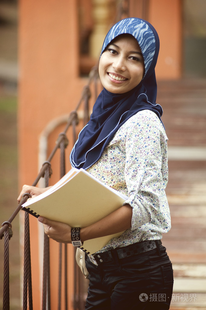 同时在 bri 拿书的年轻穆斯林美女微笑