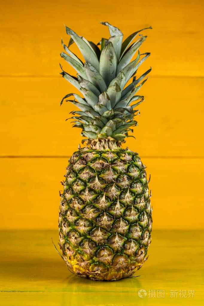 成熟的菠萝木在黄色背景上