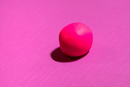 粉红色背景下的单红色橡皮泥球