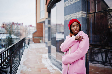 非洲裔美国女孩在红色帽子和粉红色外套在城市街道
