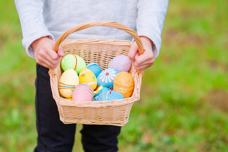 儿童手上的彩色复活节彩蛋特写篮子