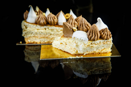 切片的美味双层基辅蛋糕丰富的装饰与巧克力奶油和坚果特写黑色镜子