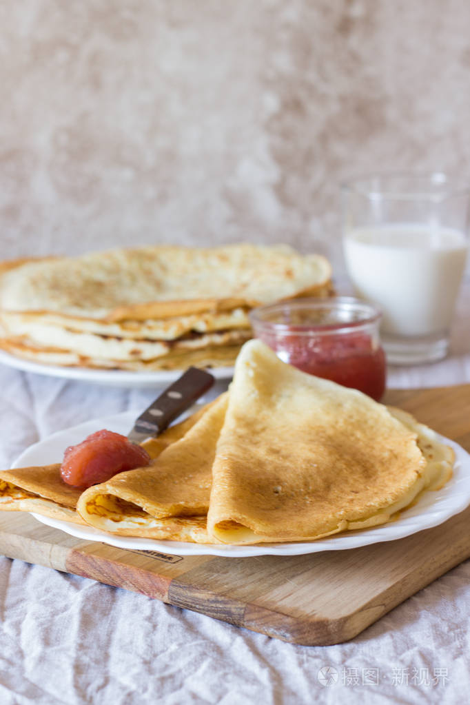 传统的俄罗斯甜薄煎饼与果酱在白色的盘子和光的背景自制早餐