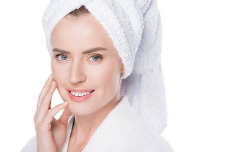 妇女与干净的皮肤浴袍和毛巾在头发触摸自己的脸上孤立的白色