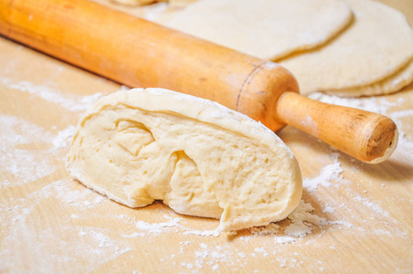 麦子面粉面粉卷在木桌上碾压的麦子面团和辗压别针照片