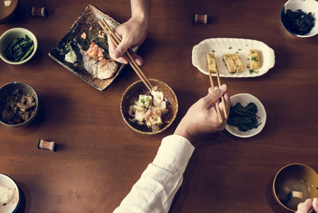 日粮摆在餐桌上, 人们用木筷吃饭