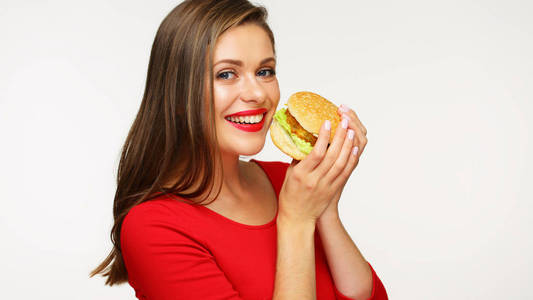 穿着红色礼服的微笑的妇女持有大汉堡
