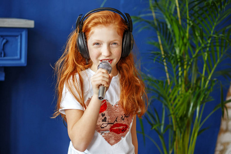 一个红头发的小女孩唱着歌.概念是童年照片