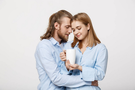 可爱的年轻白人情侣的肖像放松一起拥抱和享受热咖啡
