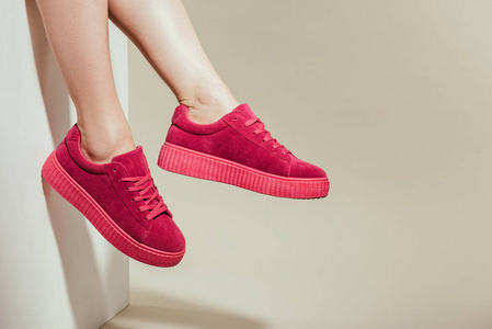 白色背景时尚时尚运动鞋女性脚裁剪拍摄照片