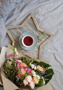 一束鲜花和一杯茶在灰色的背景。顶部视图