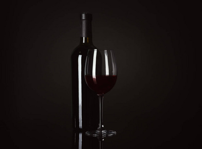 瓶子和杯子在黑色背景上的红酒