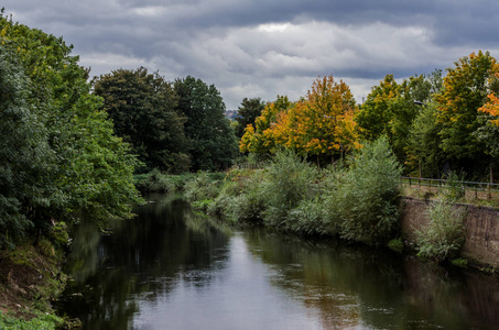 英格兰北部一条杂草丛生被忽视的河流的城市景观场景